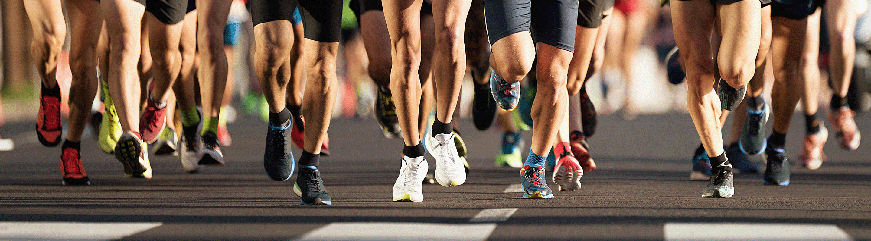 Nahaufnahme der Beine von Marathonläufern auf einem Wettkampf mit Laufsocken gegen Blasen von Wrightsock.