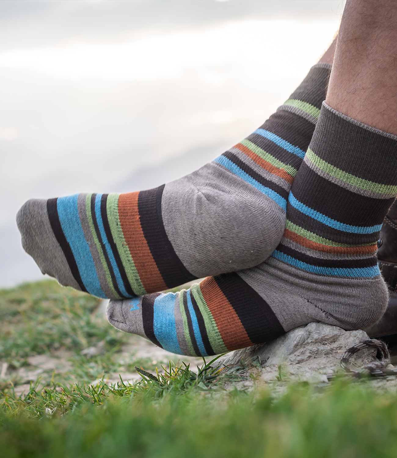 Gestreifte Wandersocken Stride Crew von Wrightsock vor Bergkulisse.