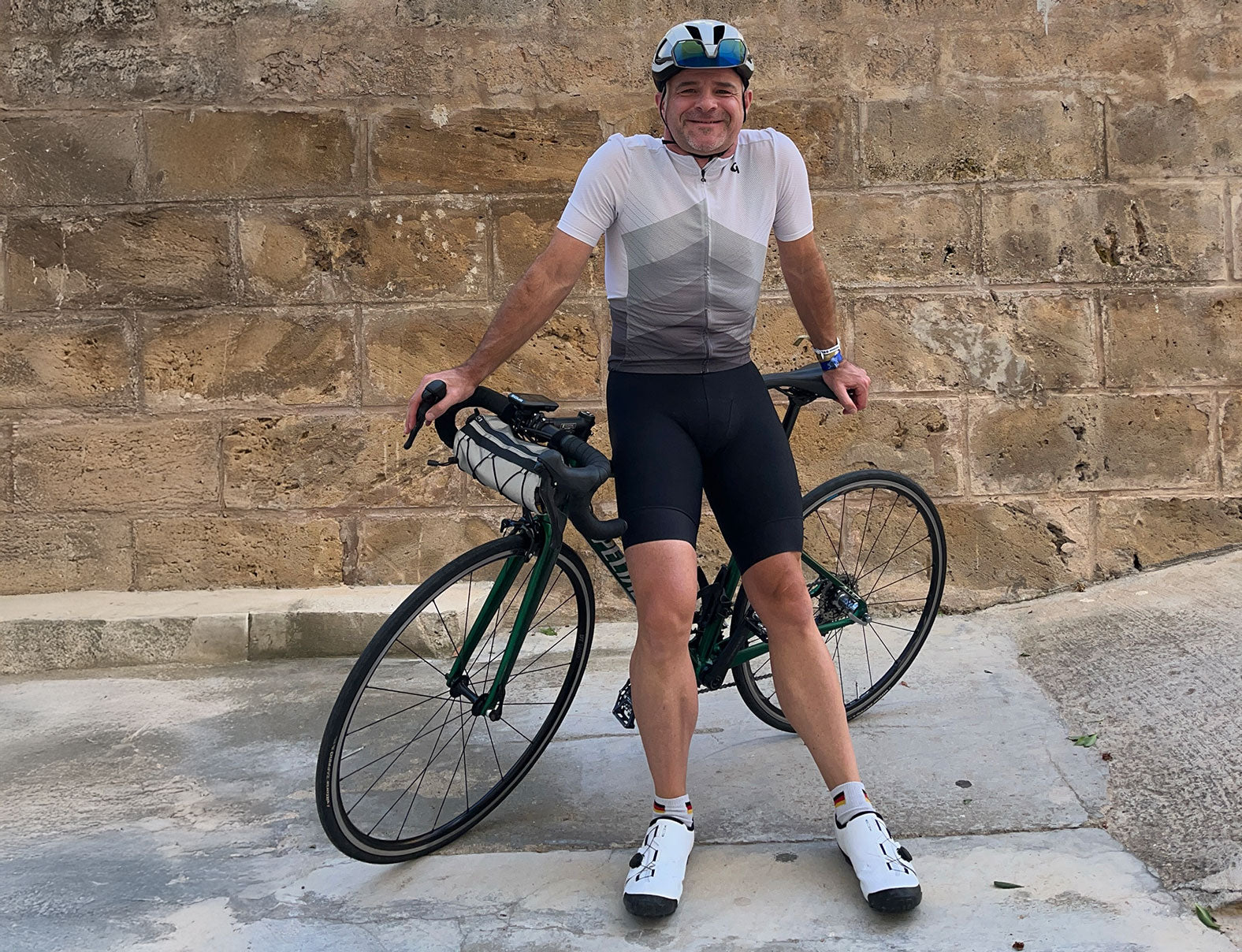 Markenbotschafter Frank Bauknechtim Fahrraddress vor seinem Rennrad stehend